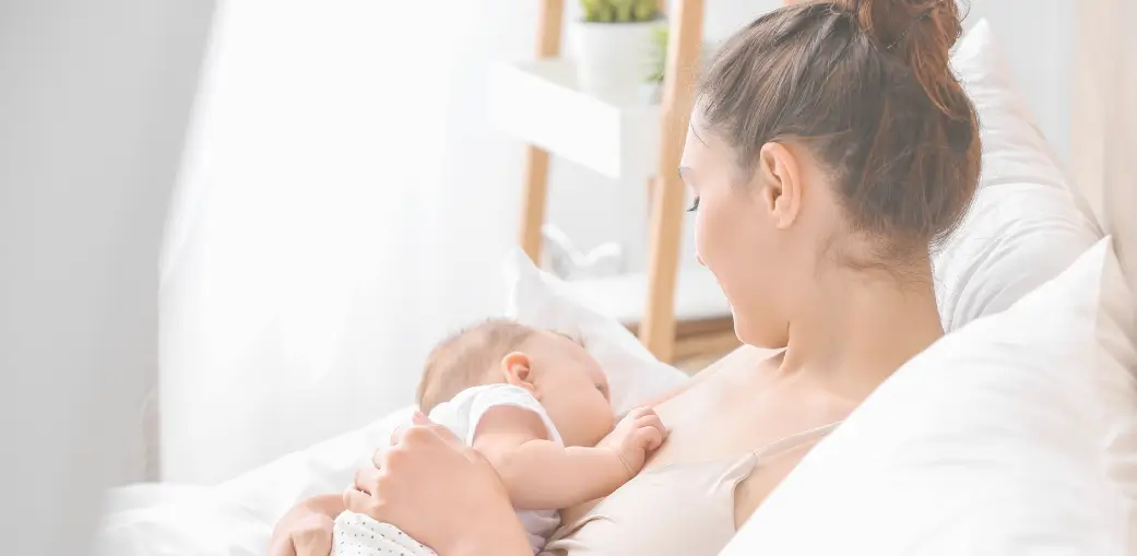 Madre practicando la lactancia en un ambiente tranquilo y luminoso, representando un momento de conexión íntima con su bebé.
