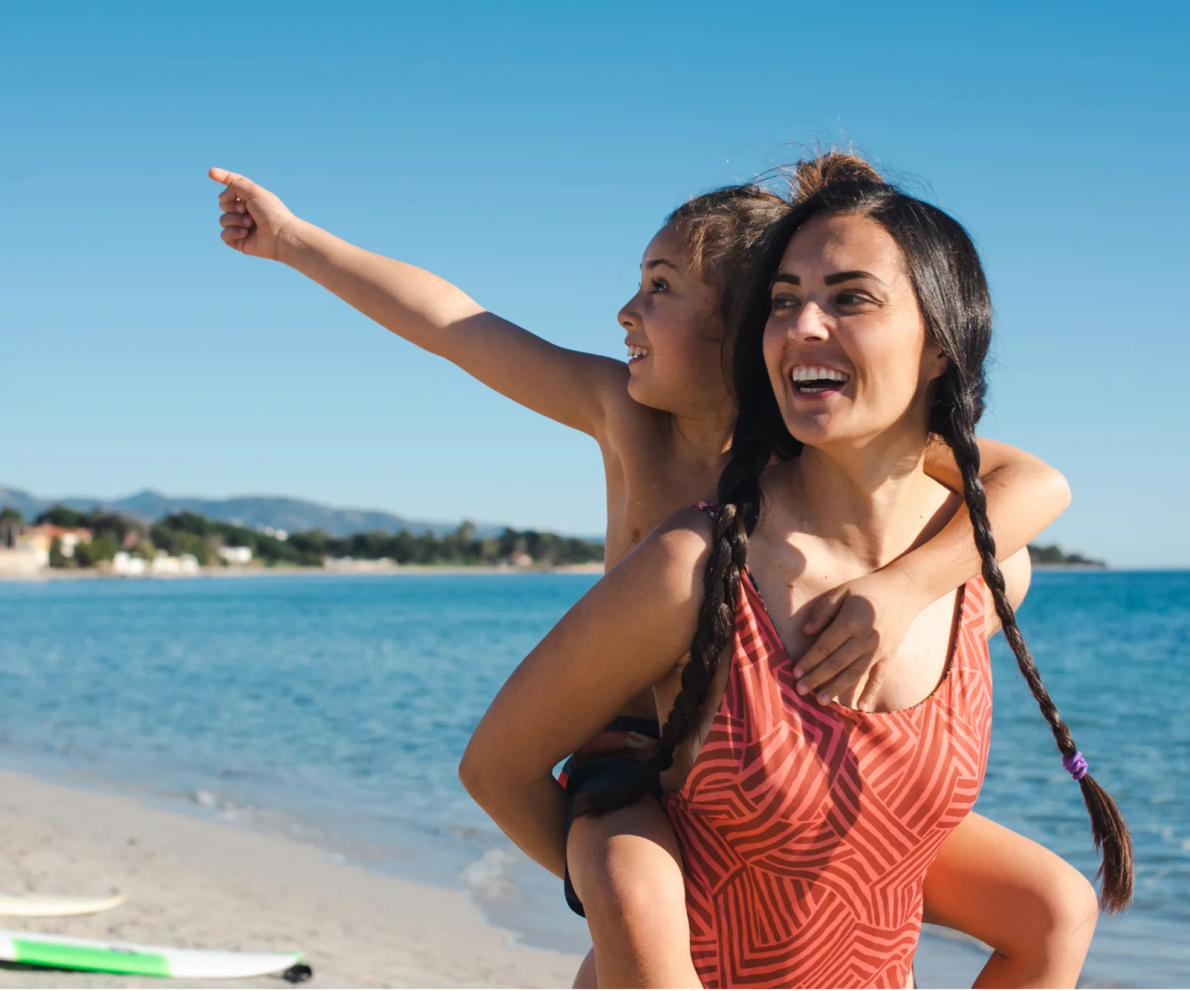 Una madre y su hija en la playa jugando. Muestra el bienestar de haber compaginado la maternidad con su identidad como mujer. Terapéuta emocional y life coach para madres. Presencial y online en Palma de Mallorca