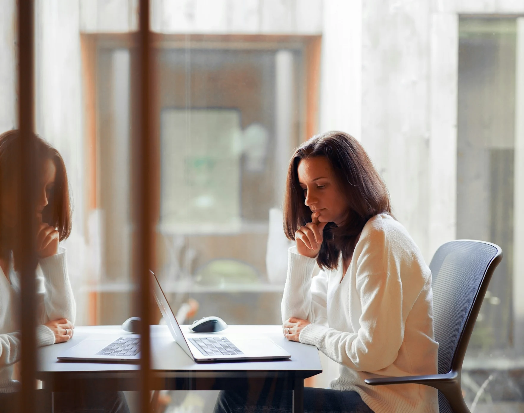 En la imagen hay una mujer en su oficina mirando a su portátil. Simboliza la decisión de no ser madre y sentirse bien con ello. Rocío Mesa. Terapéuta emocional y life coach para madres. Presencial y online en Palma de Mallorca